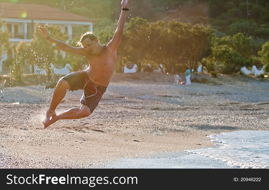 Teenager do an acrobatic figure in the air on the beach. Teenager do an acrobatic figure in the air on the beach