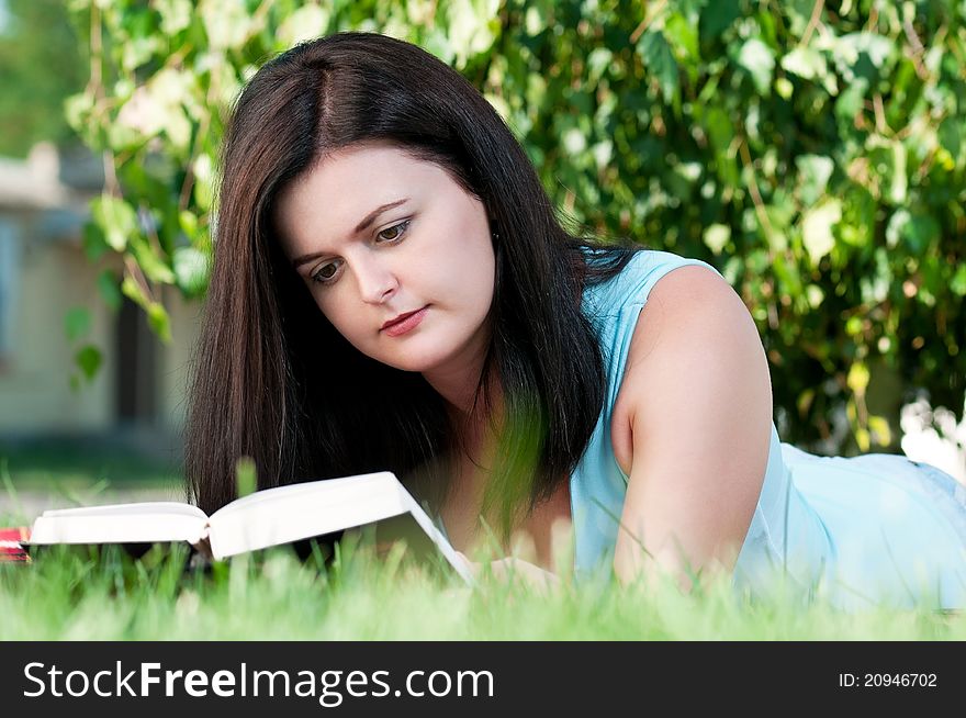 Portrait of a young female student with book at the campus