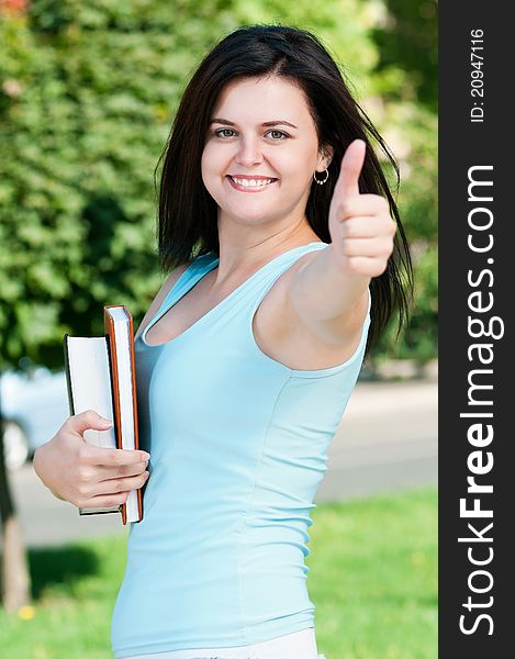 Portrait of a young female student with books at the campus