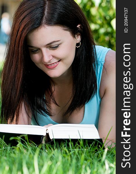 Portrait of a young female student with book at the campus