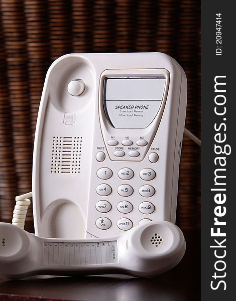 A white telephone with the earpiece off the hook