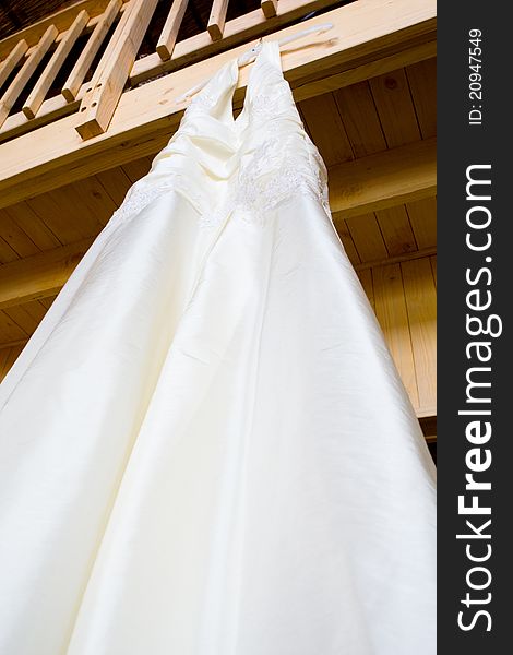 A hanging wedding dress photographed from below