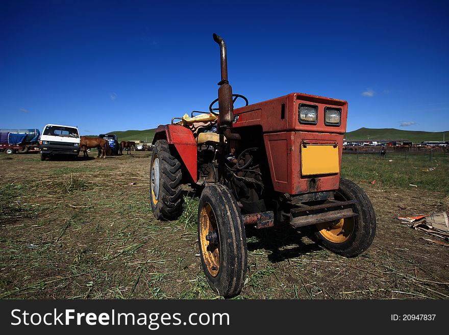 An old tractor on the grass field.