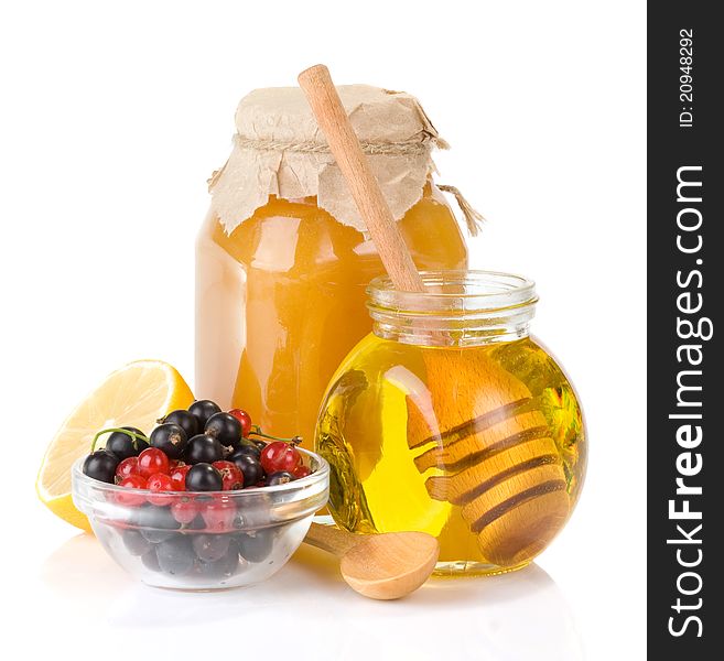 Glass jar full of honey and berry on white background