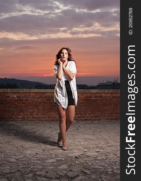 Fashionable model posing, dramatic sunset backgrou