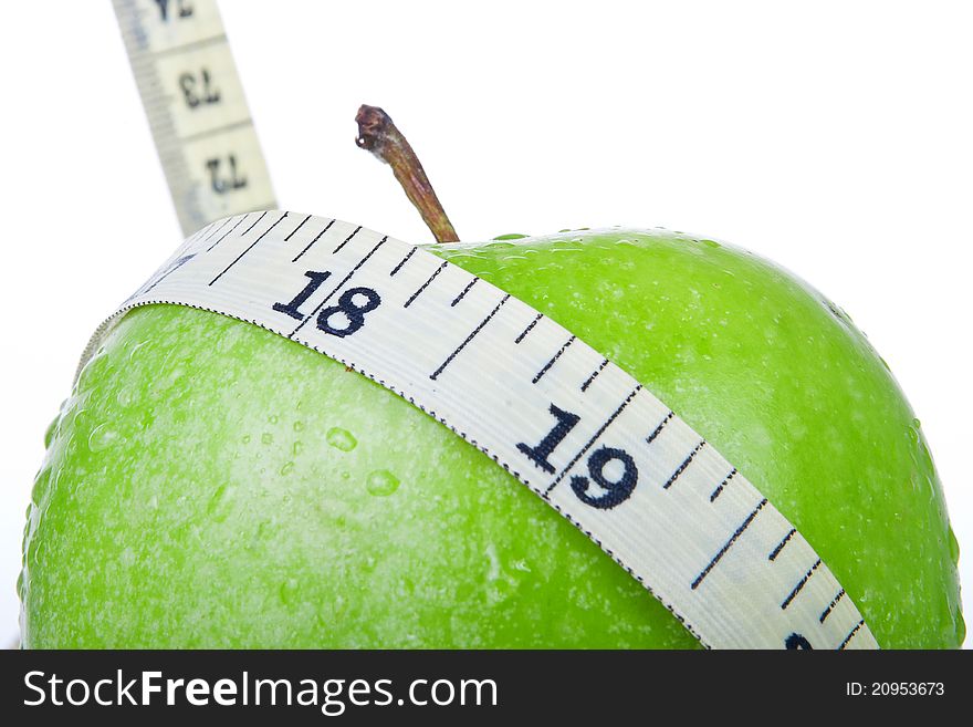 Green apple with tape measure isolated on white background