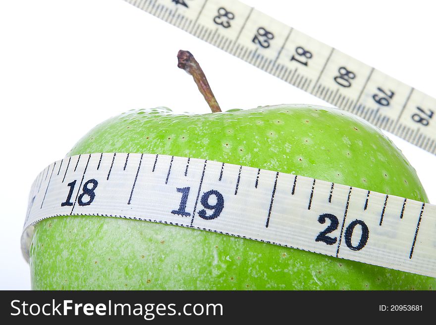 Green apple with tape measure isolated on white background