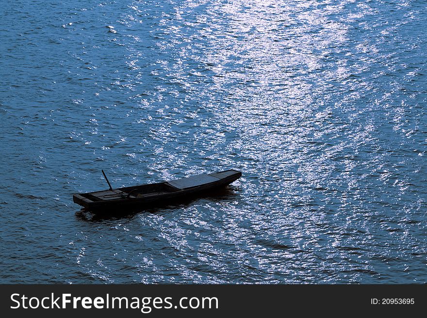 A wood boat lay at anchor in the bay。