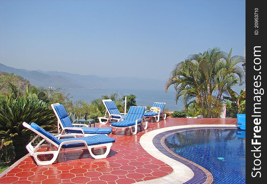 View of puerto vallarta ocean poolside with beach chairs. View of puerto vallarta ocean poolside with beach chairs