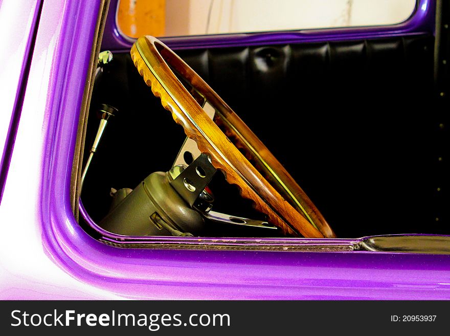 Image of the steering wheel of a purple hot rod car