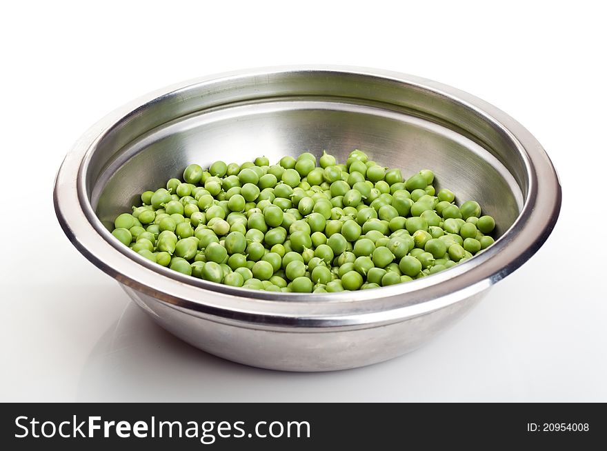 Fresh green peas in a metal plate isolated on a white background