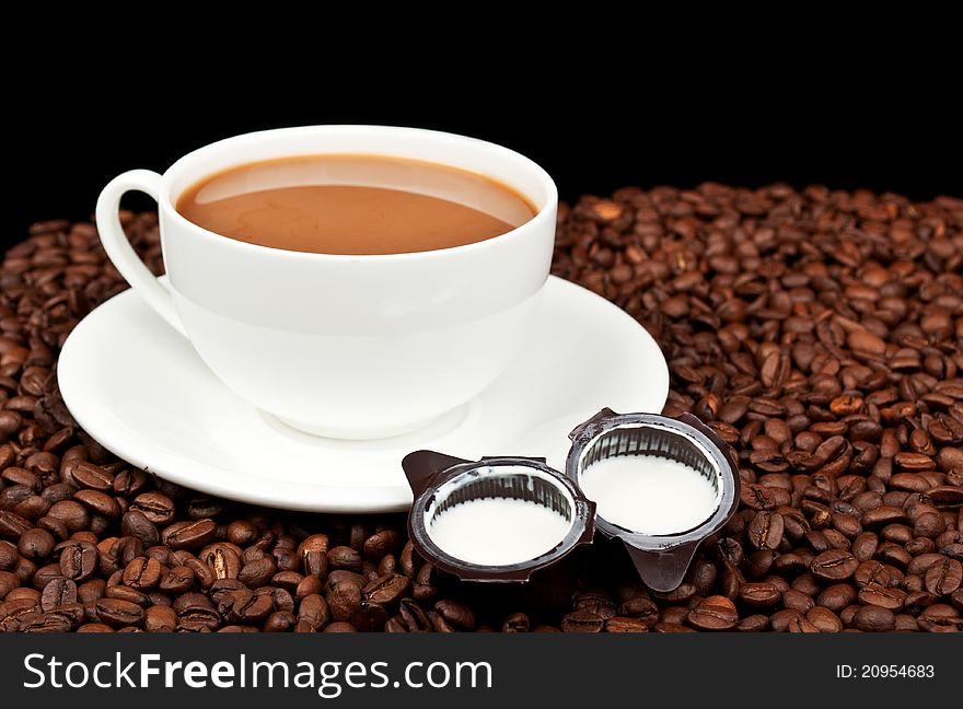 Coffee with milk and coffee beans on a black background. Coffee with milk and coffee beans on a black background