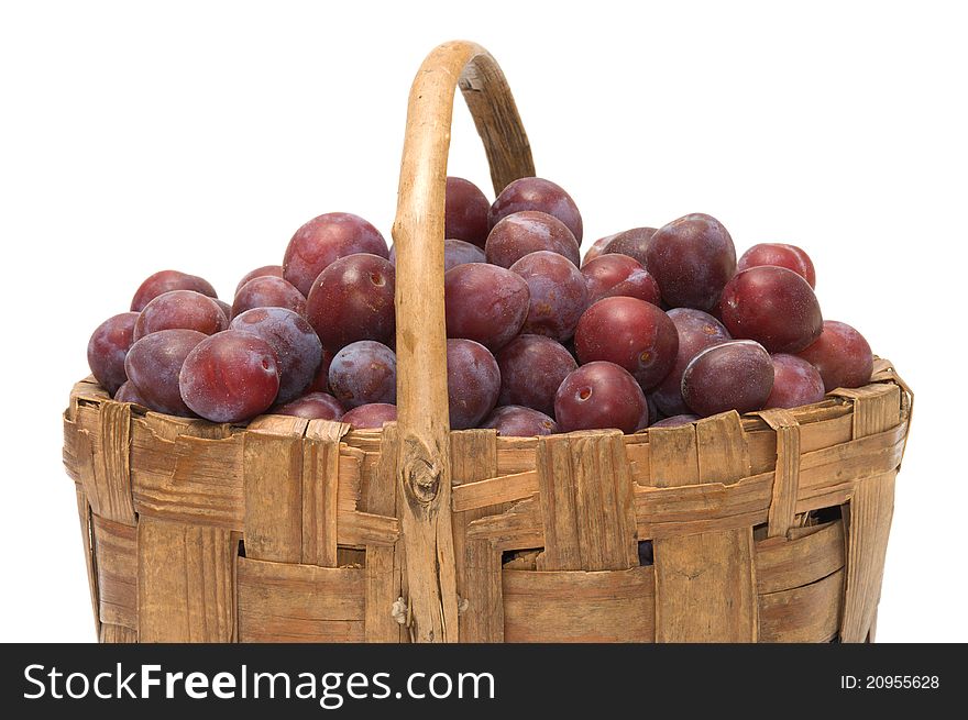 Wattled basket with ripe plums it is isolated on a white background. Wattled basket with ripe plums it is isolated on a white background.