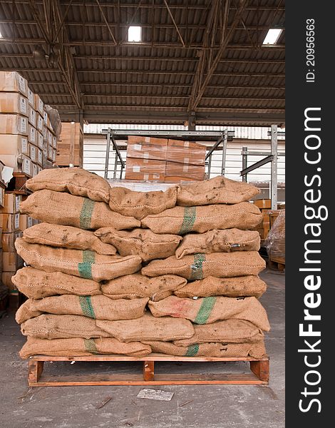 Brown sacks stack on wooden pallet in stockpile. Brown sacks stack on wooden pallet in stockpile