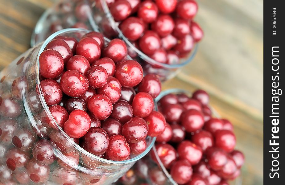 Cherries in glass jars. Cherry on a wooden table. Harvesting of berries for the winter. Cherries in glass jars. Cherry on a wooden table. Harvesting of berries for the winter.