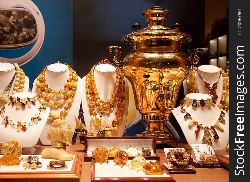 The big gold samovar and ornaments from amber in a bright show-window of gift shop in Moscow on Arbat. The big gold samovar and ornaments from amber in a bright show-window of gift shop in Moscow on Arbat