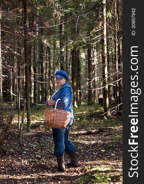 Woman in the forest with wooden basket in hands
