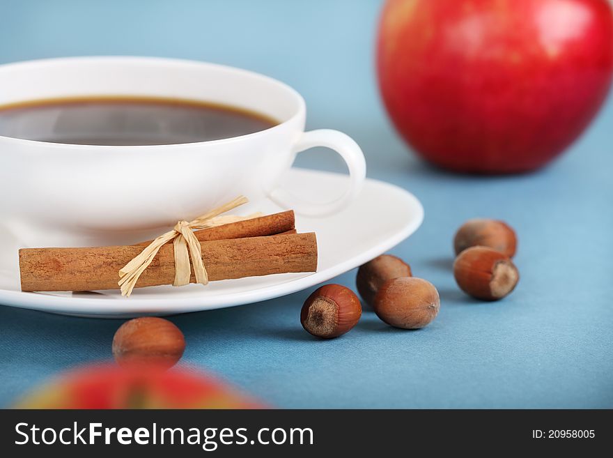 Coffee with cinnamon and apples on the blue background. Coffee with cinnamon and apples on the blue background