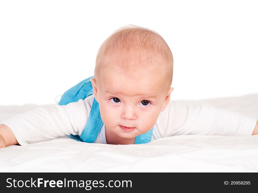 Portrait of a cute baby lying on bed on a white. Portrait of a cute baby lying on bed on a white