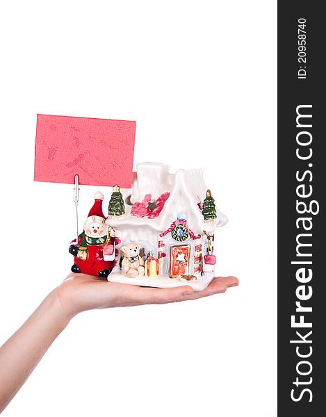 Hand holding toy house and snowman with business card over white. Hand holding toy house and snowman with business card over white