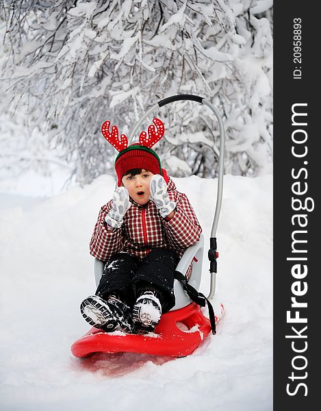 Adorable child girl sits in sled on a bright winter day. Adorable child girl sits in sled on a bright winter day