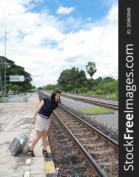 Young traveling woman with her suitcases on the railway tracks. Young traveling woman with her suitcases on the railway tracks