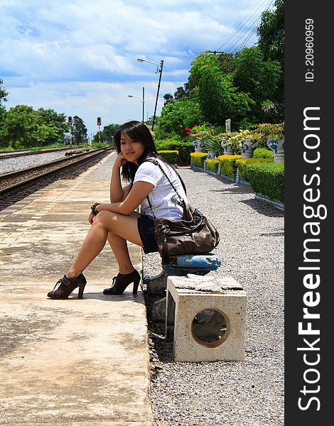 Young traveling woman with her suitcases on the railway tracks. Young traveling woman with her suitcases on the railway tracks