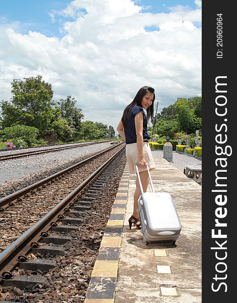 Young traveling woman with her suitcases on the railway tracks. Young traveling woman with her suitcases on the railway tracks