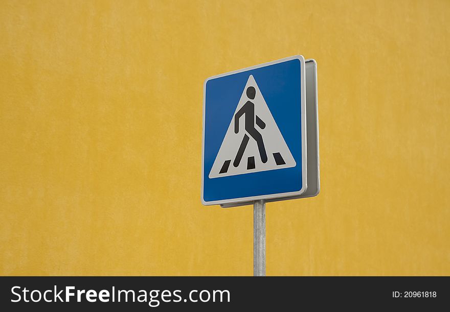 Crosswalk road sign on yellow background