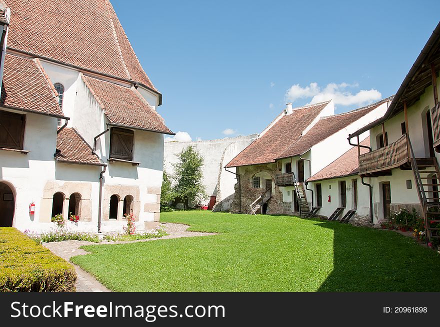 Interior courtyard of the fortified church of Harman in rural Romania. Old houses inside a small stronghold. Interior courtyard of the fortified church of Harman in rural Romania. Old houses inside a small stronghold