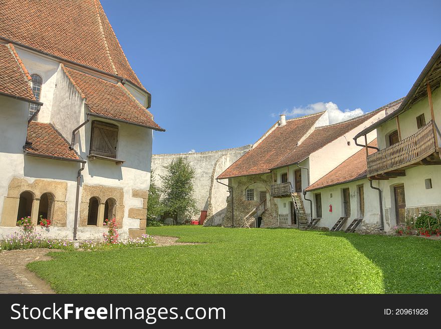 Interior courtyard of the fortified church of Harman in rural Romania. Old houses inside a small stronghold. Interior courtyard of the fortified church of Harman in rural Romania. Old houses inside a small stronghold