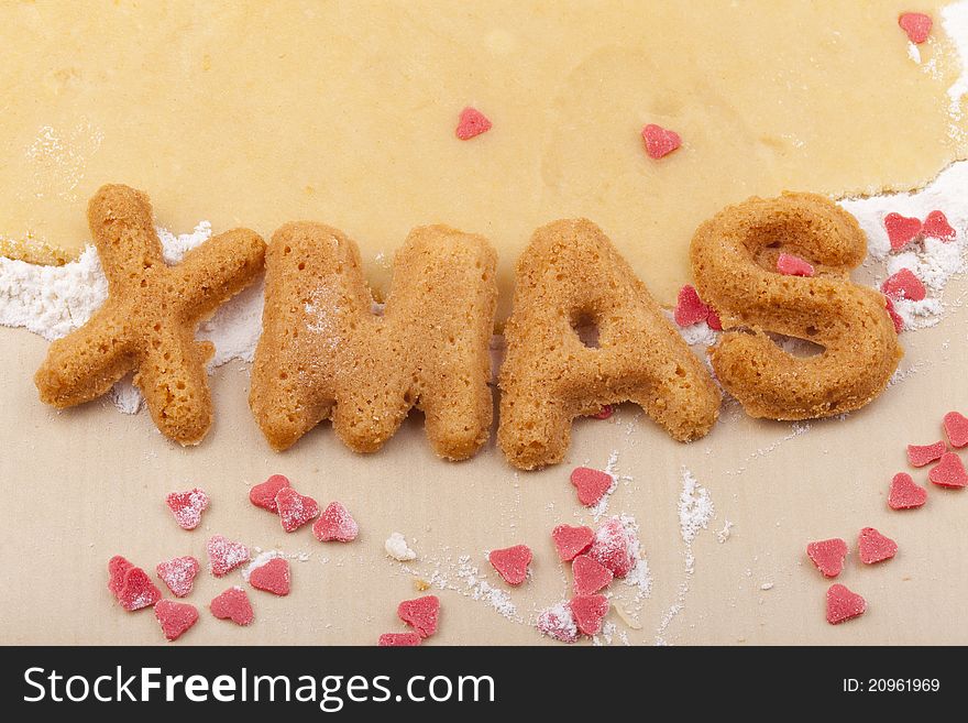 Studio-shot of preparing and baking cookies for christmas. baked letter biscuits spelling out the word xmas. Studio-shot of preparing and baking cookies for christmas. baked letter biscuits spelling out the word xmas.