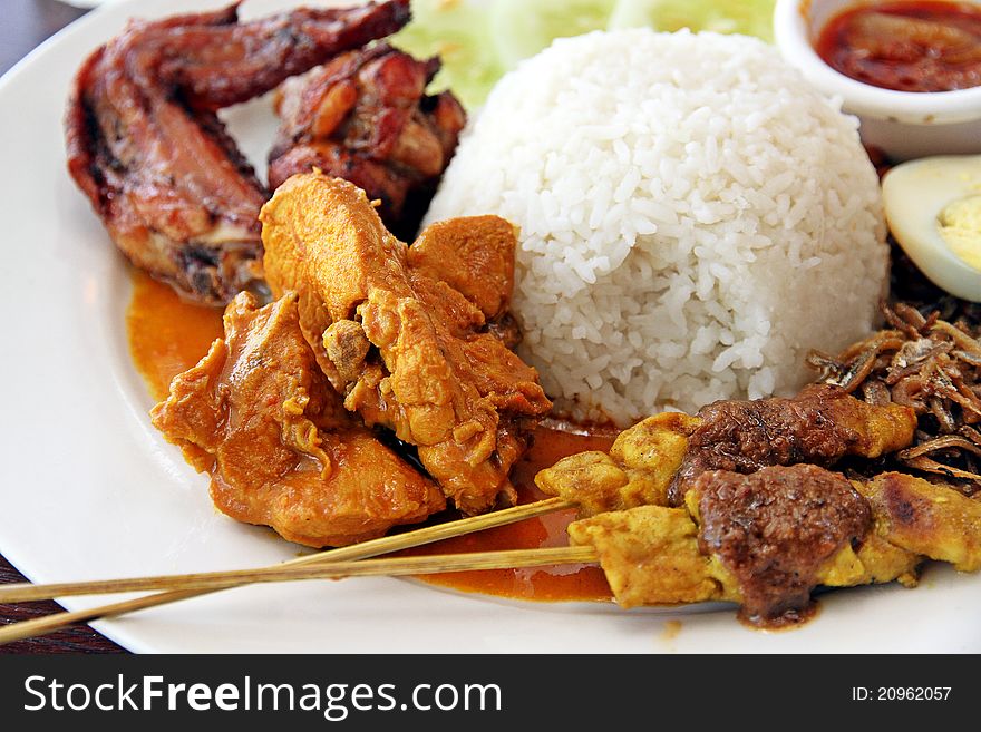 Delicious nasi lemak with BBQ chicken, curry chicken and satay stick. Delicious nasi lemak with BBQ chicken, curry chicken and satay stick.