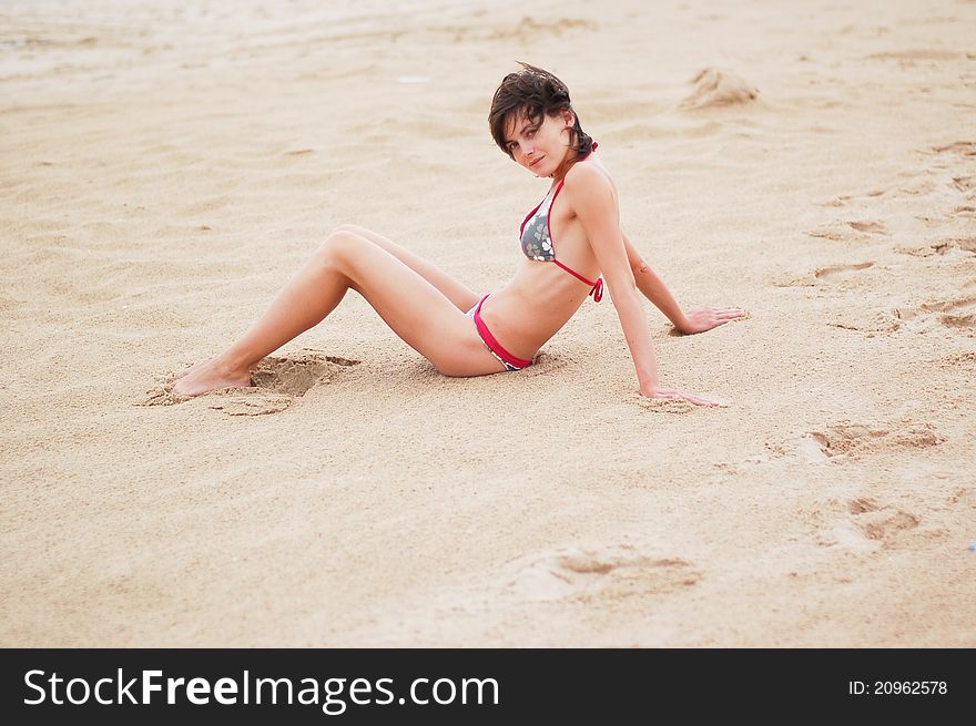 Young woman on the beach near the sea meditating