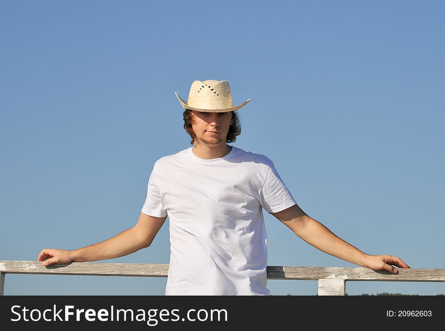 Young man straw hat against blue sky. Young man straw hat against blue sky