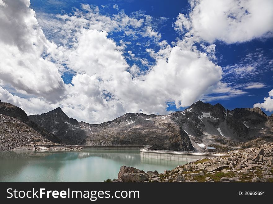 Dam and man-made lake between mountains. Itâ€™s Venerocolo Lake, North of Italy, Lombardy region, at 2.540 meters on the sea-level. Dam and man-made lake between mountains. Itâ€™s Venerocolo Lake, North of Italy, Lombardy region, at 2.540 meters on the sea-level