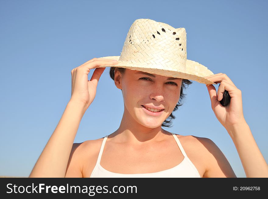Young woman straw hat against blue sky. Young woman straw hat against blue sky