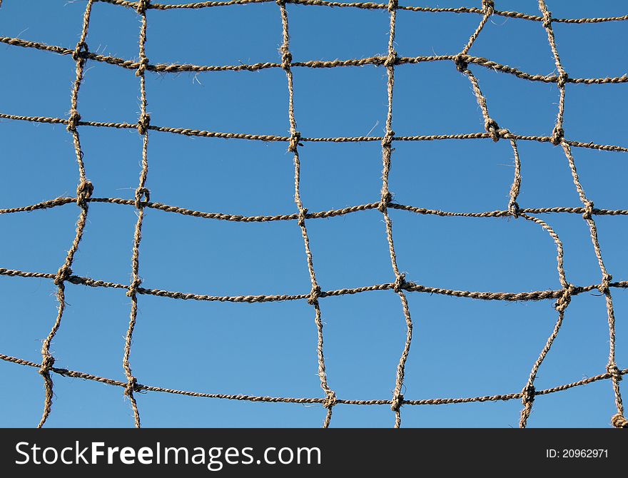 Rope chain with a large hole and the blue sky. Rope chain with a large hole and the blue sky