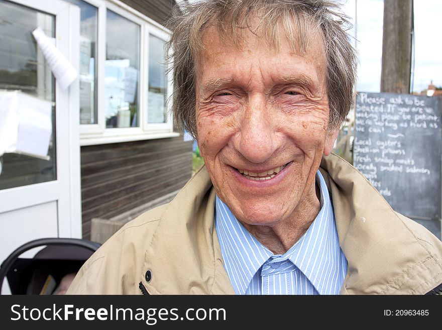 Retired man smiling outside wearing a jacket in spring. Retired man smiling outside wearing a jacket in spring