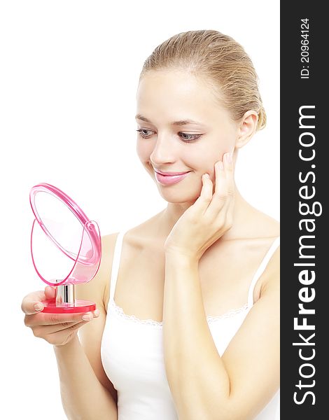 Girl looking into a hand mirror isolated on a white background. Girl looking into a hand mirror isolated on a white background