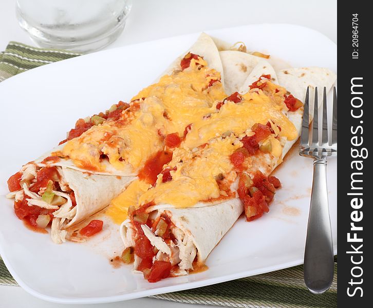 Two chicken fajitas topped with cheese on a plate