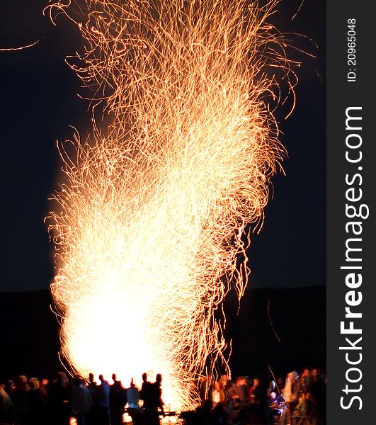 Big outdoor fire (campfire) with people silhouette, yellow red smoke