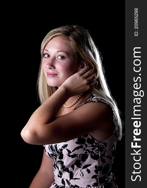 Beautiful young blond model posing in studio against black backdrop. Beautiful young blond model posing in studio against black backdrop