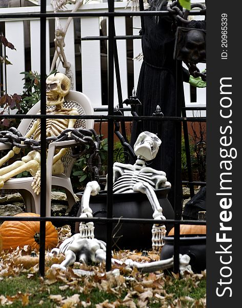 Halloween decorations behind bars in a neighborhood yard.