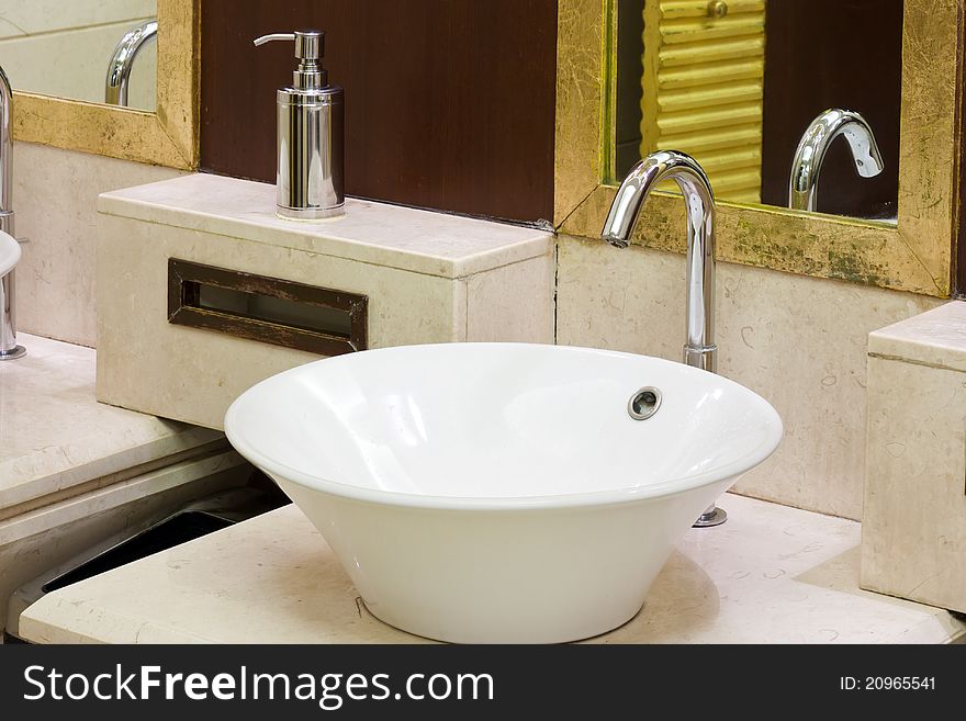 Washbasins, taps and mirror in a public toilet