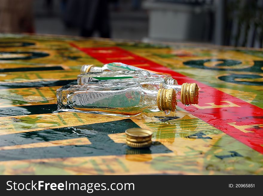 Empty bottles on a rain-soaked table