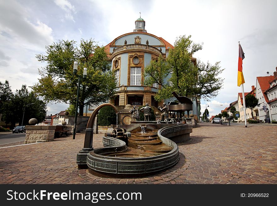 German village city hall with carved bronze fountain. Black Forest, south Germany