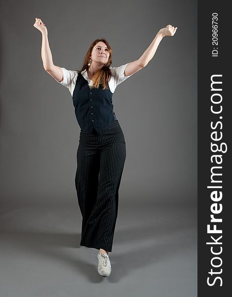 Caucasian female jazz dancer poses in front of a studio gray backdrop.