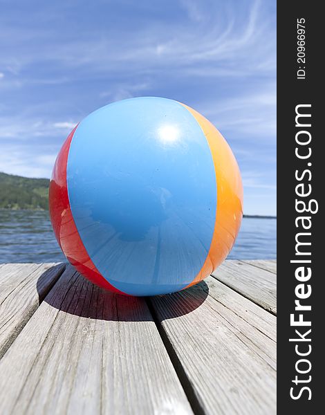 Colorful beachball on a dock in full summer sun