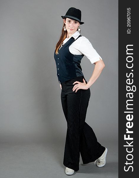 Caucasian female jazz dancer poses in front of a studio gray backdrop.